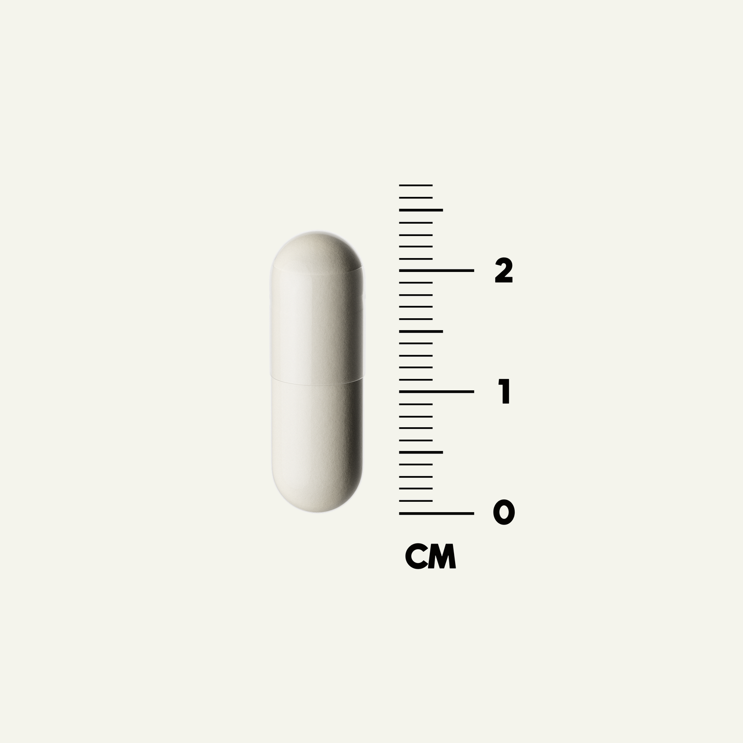 Grass-Fed Bone Matrix capsule next to a ruler, measuring 2 cm in height.