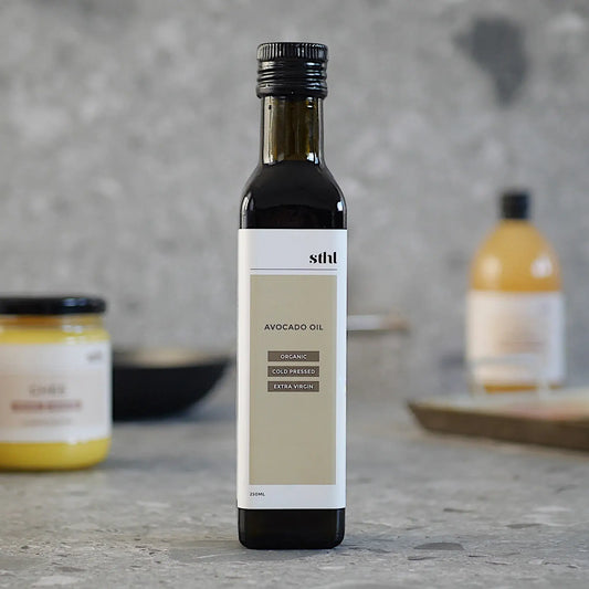 STHL Organic Avocado Oil, cold-pressed and extra virgin, in a sleek bottle on a kitchen counter.